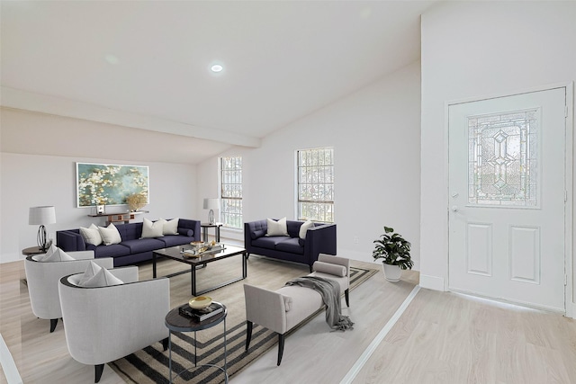 living room featuring light wood-type flooring and vaulted ceiling with beams