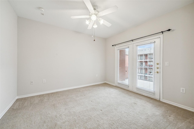 spare room featuring light carpet and ceiling fan