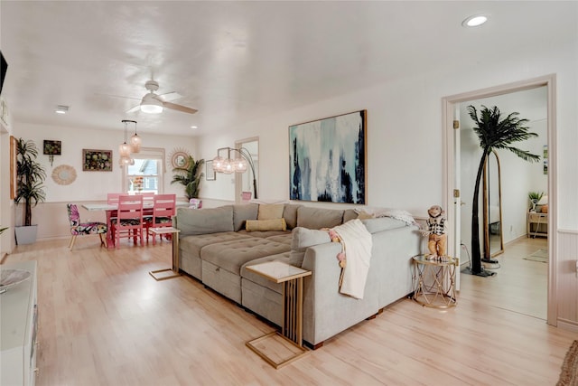 living room with light hardwood / wood-style flooring and ceiling fan