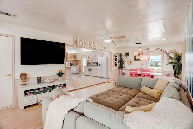 living room with ceiling fan and light hardwood / wood-style floors