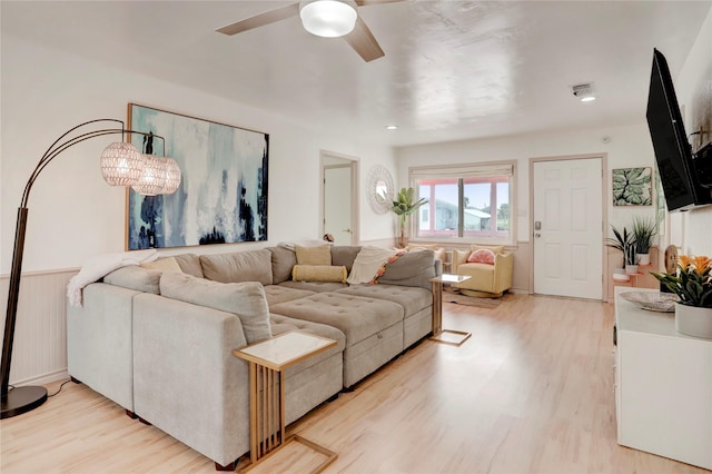 living room with ceiling fan with notable chandelier and light wood-type flooring