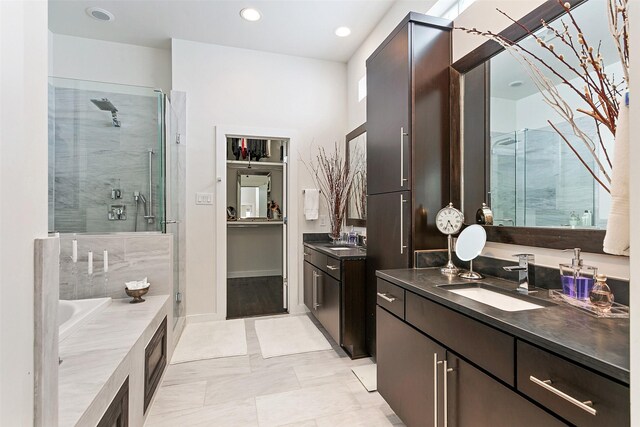 bathroom featuring plus walk in shower, vanity, and tile patterned flooring