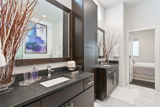 ensuite bathroom featuring ensuite bath, two vanities, and a sink