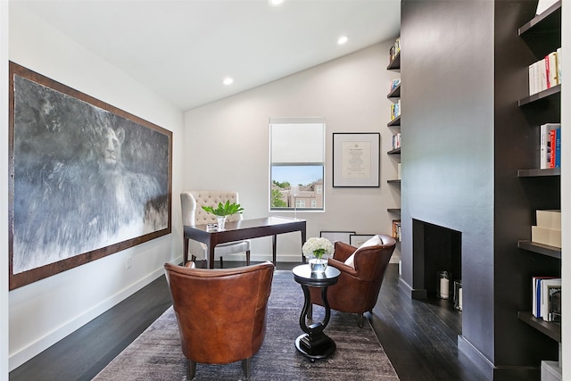 office space with a fireplace, dark wood-type flooring, and lofted ceiling