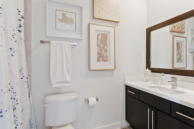 bathroom with vanity, toilet, and curtained shower