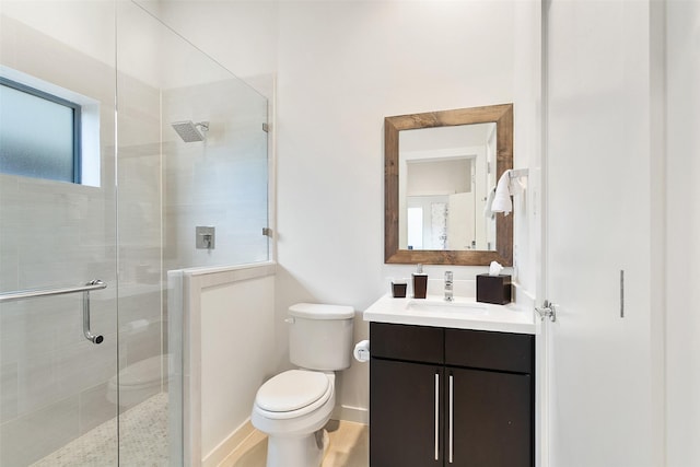 full bath with toilet, a shower stall, baseboards, and vanity