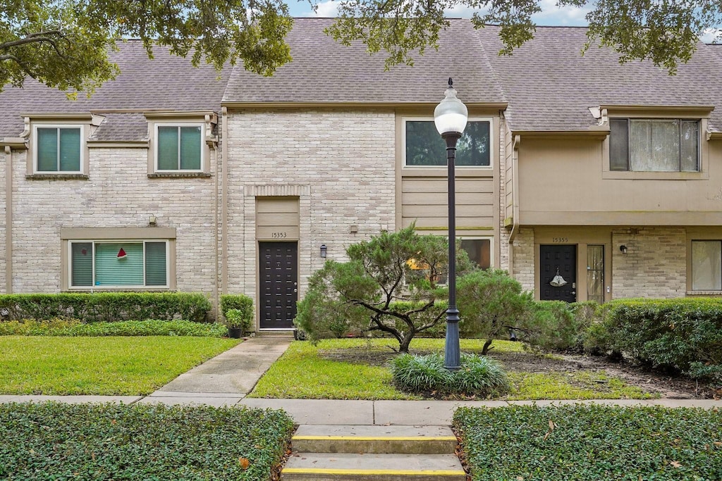 townhome / multi-family property featuring a front lawn