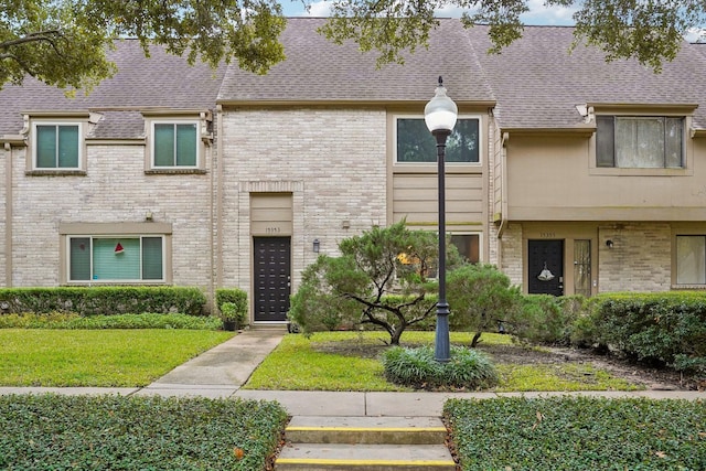 townhome / multi-family property featuring a front lawn