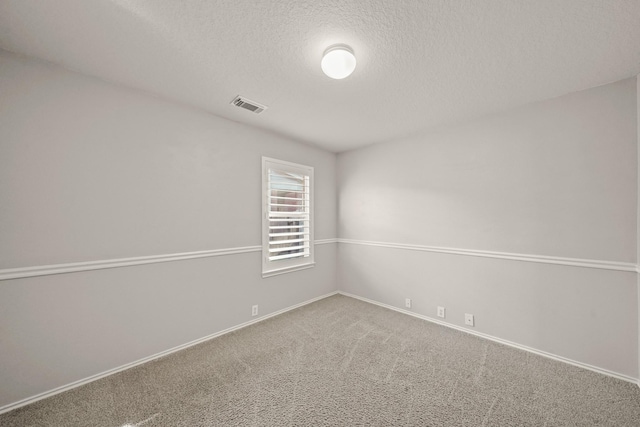 carpeted spare room featuring a textured ceiling