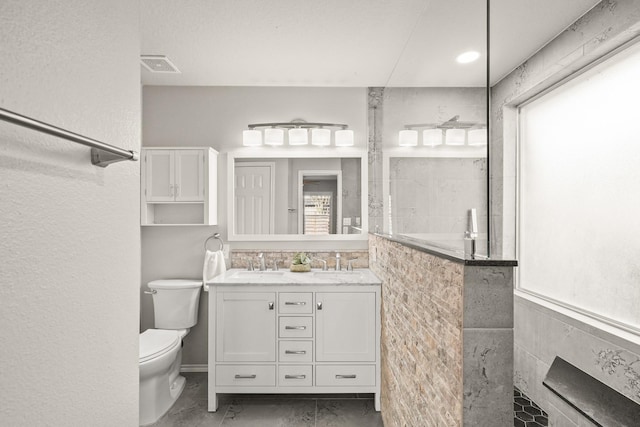 bathroom with plenty of natural light, toilet, a shower, and vanity