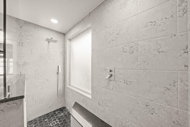 bathroom featuring plenty of natural light and tiled shower