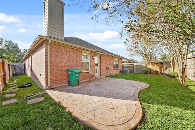 rear view of house with central air condition unit, a yard, and a patio