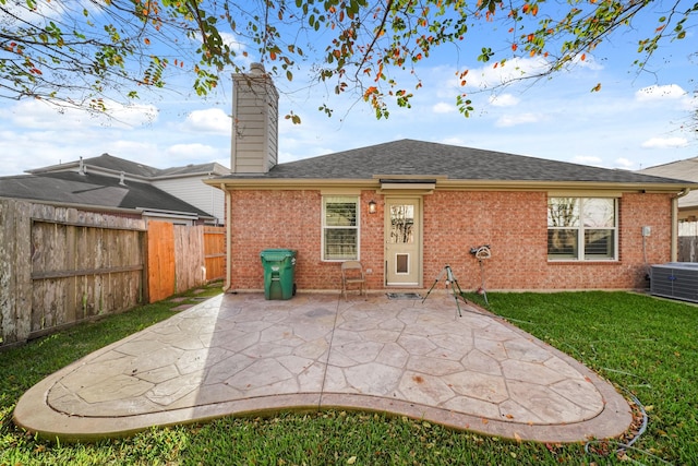 rear view of property with a yard, a patio, and central air condition unit