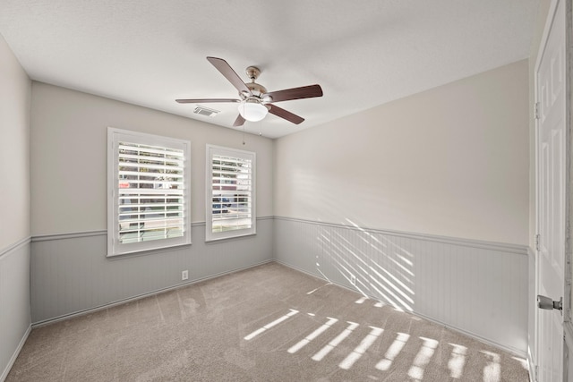 carpeted spare room featuring ceiling fan