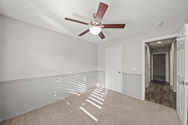 carpeted spare room featuring ceiling fan