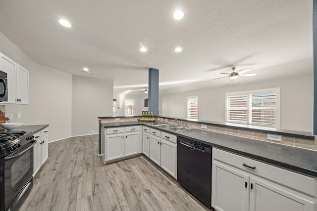 kitchen with white cabinetry, sink, black appliances, and light hardwood / wood-style floors