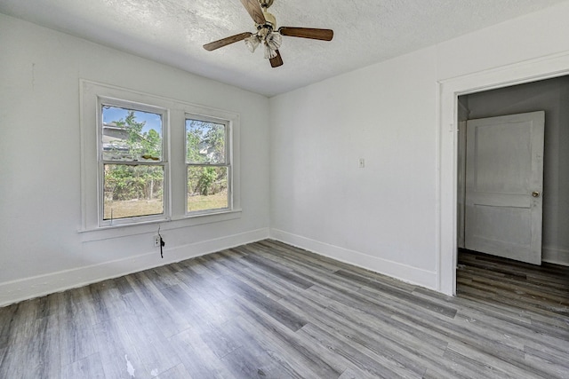 spare room with ceiling fan, hardwood / wood-style floors, and a textured ceiling