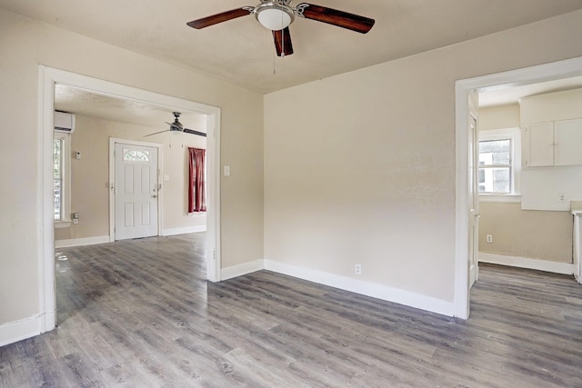 7025 Canal St, Houston, TX 77011 - unfurnished room featuring ceiling fan, a wall unit AC, and wood finished floors