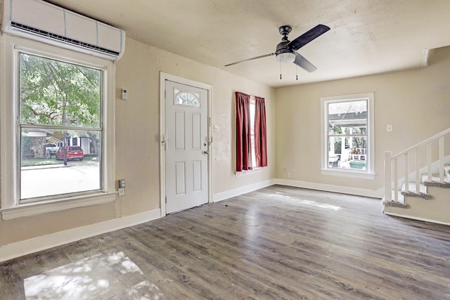 7025 Canal St, Houston, TX 77011 - entrance foyer featuring an AC wall unit, wood finished floors, stairway, and healthy amount of natural light