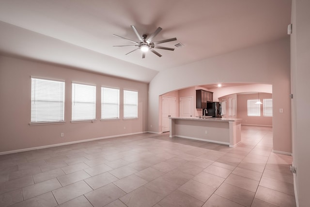 unfurnished living room featuring ceiling fan, light tile patterned floors, and lofted ceiling