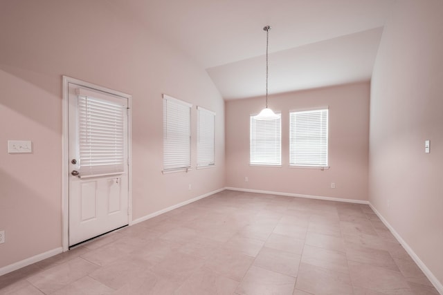 unfurnished room with light tile patterned floors and vaulted ceiling