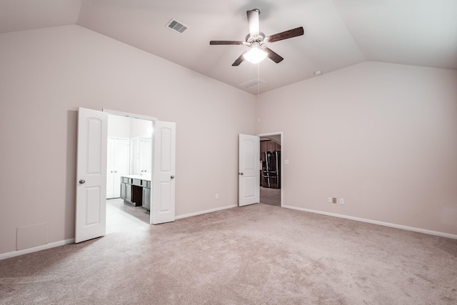 unfurnished bedroom featuring black refrigerator, light colored carpet, vaulted ceiling, and ceiling fan