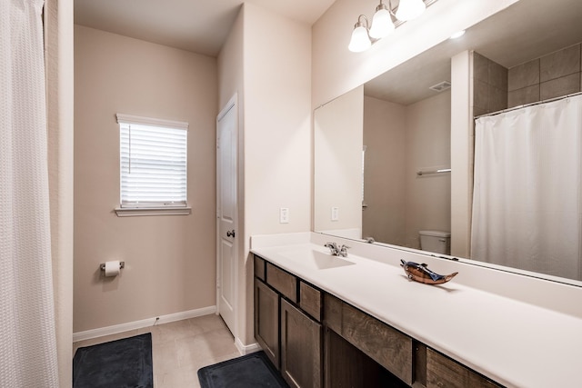 bathroom with vanity, toilet, and curtained shower