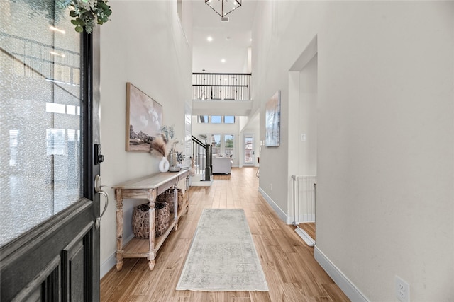 entryway featuring light hardwood / wood-style flooring and a towering ceiling