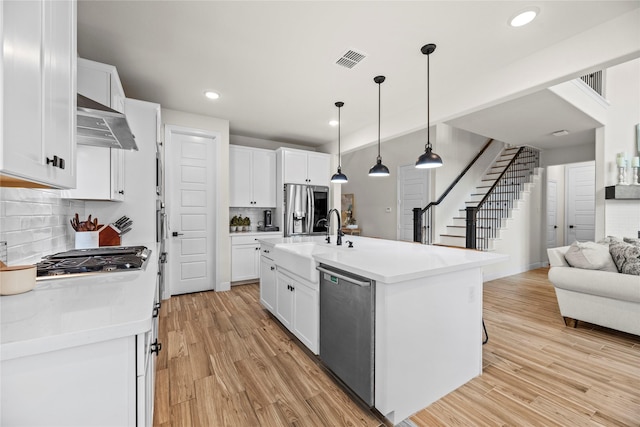 kitchen featuring appliances with stainless steel finishes, white cabinetry, and sink