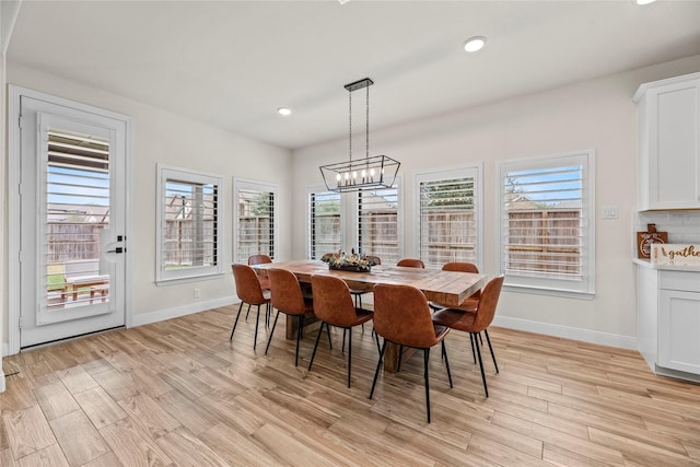 dining area with an inviting chandelier and light hardwood / wood-style flooring