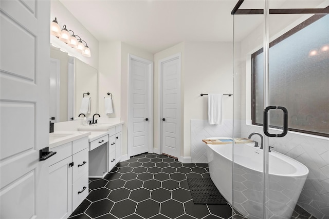 bathroom featuring tiled bath, vanity, tile walls, and tile patterned floors