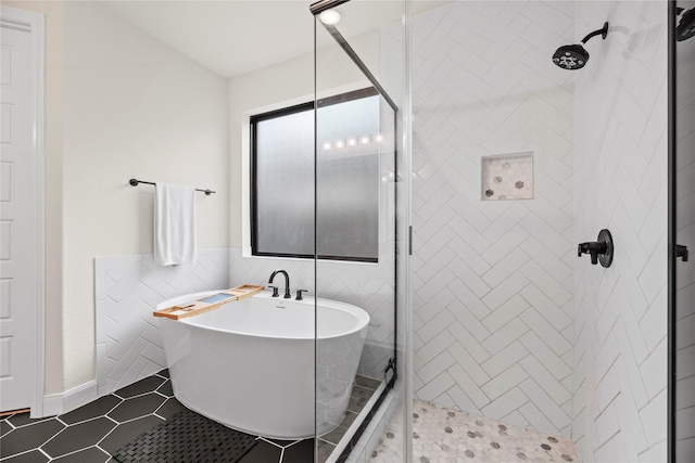 bathroom with tile patterned flooring, shower with separate bathtub, and tile walls