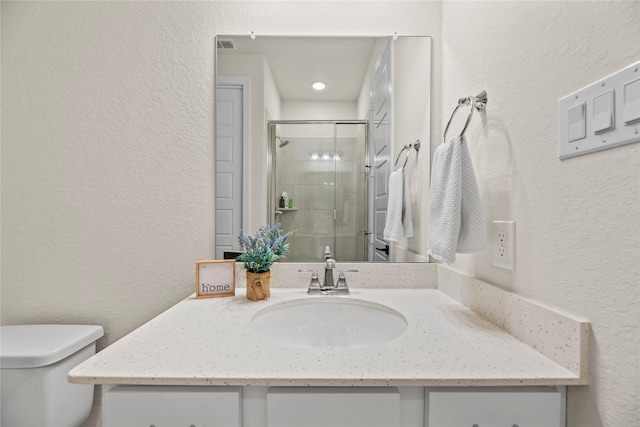 bathroom featuring an enclosed shower, vanity, and toilet