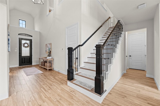 entryway featuring light wood-type flooring and a high ceiling