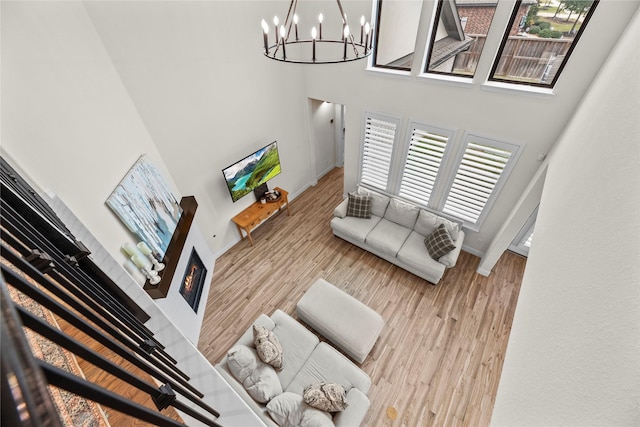 living room with hardwood / wood-style flooring, an inviting chandelier, and a high ceiling