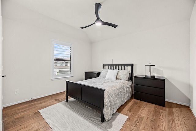 bedroom featuring ceiling fan, light hardwood / wood-style floors, and vaulted ceiling