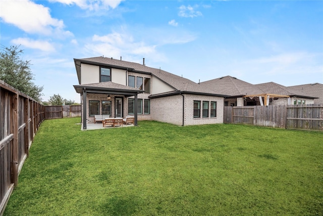 back of property featuring an outdoor hangout area, ceiling fan, a patio area, and a yard