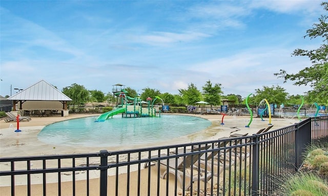 view of swimming pool with pool water feature and a water slide