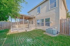 back of property featuring a lawn and central AC