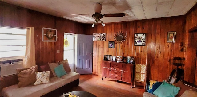 living room with ceiling fan, cooling unit, and wooden walls