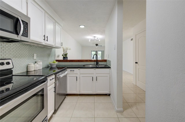 kitchen with ceiling fan, sink, stainless steel appliances, light tile patterned floors, and white cabinets