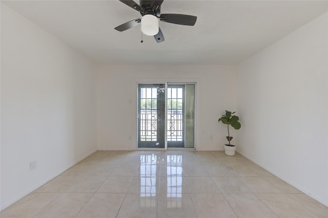 tiled empty room featuring french doors and ceiling fan