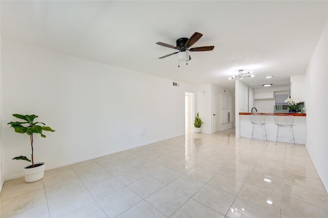 unfurnished living room with ceiling fan and light tile patterned floors