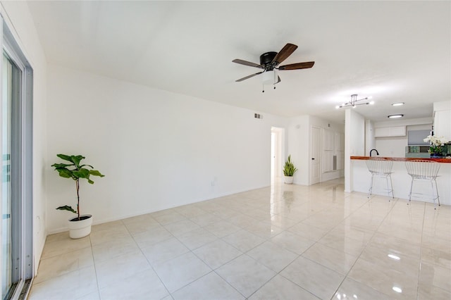 tiled empty room with ceiling fan