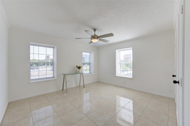 tiled spare room featuring plenty of natural light, ceiling fan, ornamental molding, and a textured ceiling