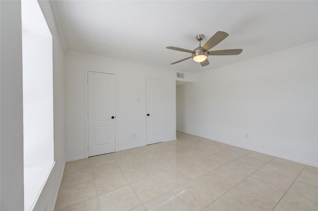 unfurnished bedroom with ceiling fan, ornamental molding, and light tile patterned flooring