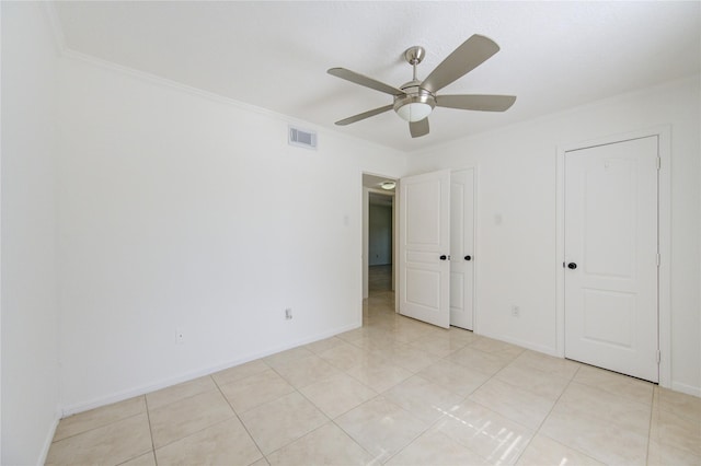 unfurnished bedroom featuring ceiling fan, light tile patterned flooring, and ornamental molding