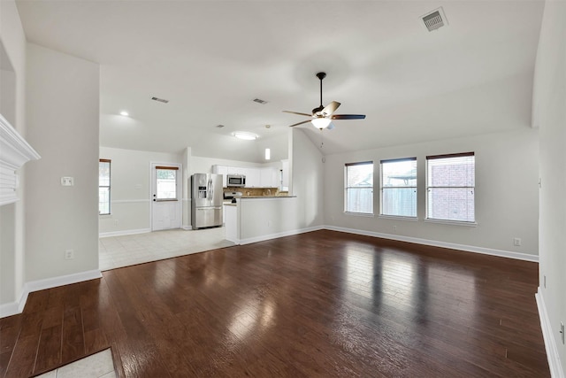 unfurnished living room featuring vaulted ceiling, light hardwood / wood-style flooring, a wealth of natural light, and ceiling fan