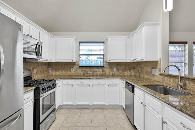 kitchen featuring appliances with stainless steel finishes, white cabinetry, plenty of natural light, and sink