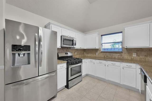 kitchen with appliances with stainless steel finishes, backsplash, stone countertops, and white cabinetry